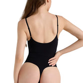 Person wearing a black swimsuit against a plain background